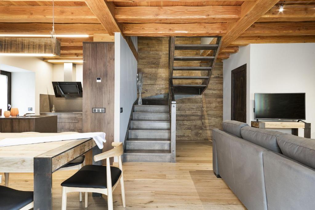 a living room with wooden ceilings and a staircase at Luderna - Casa Les er Haro in Les