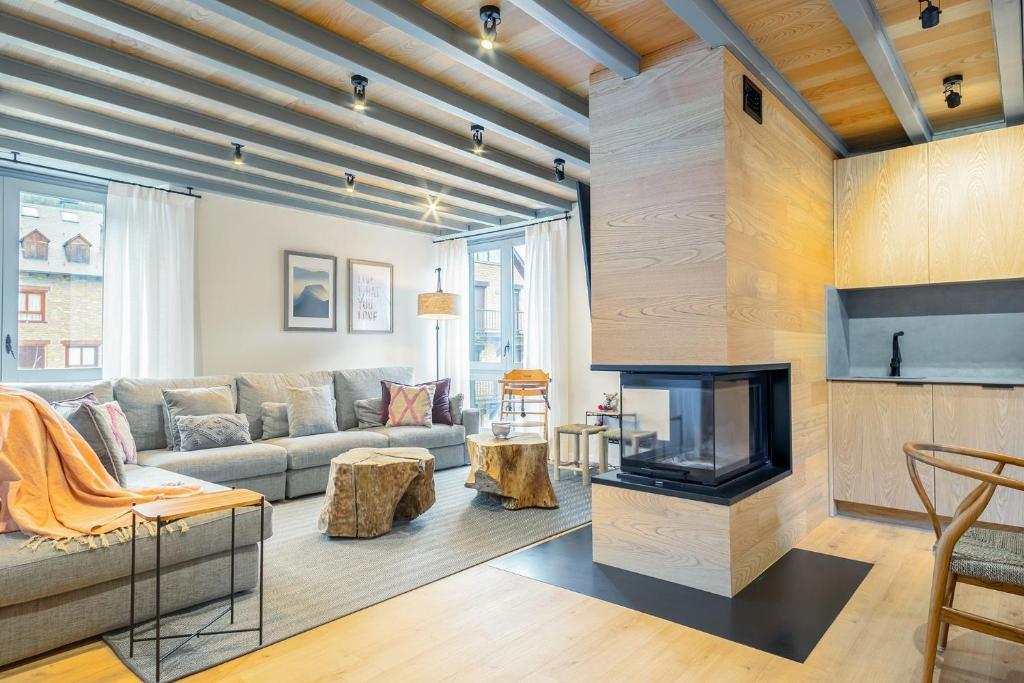 a living room with a couch and a fireplace at Luderna - Casa Carboneu in Naut Aran