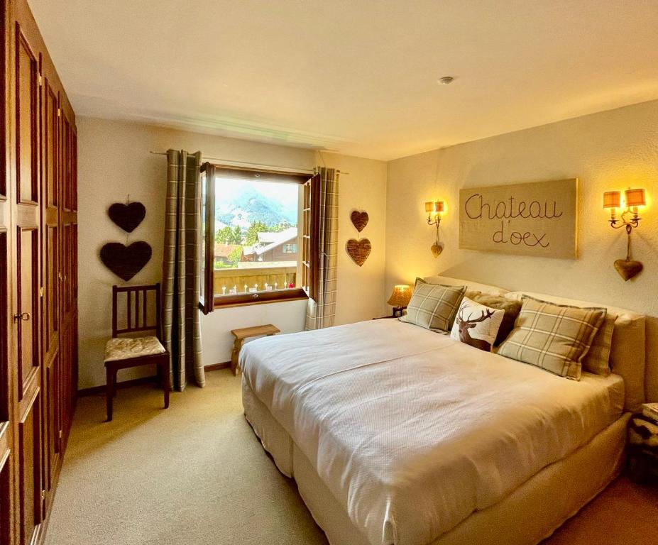 Un dormitorio con una cama grande y una ventana en Wonderful apartment overlooking the Swiss alps, en Château-d'Oex