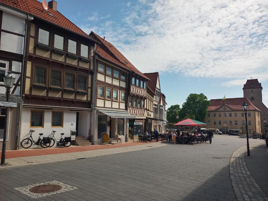 a street in a town with people sitting at tables at Haus am Markt Fewo 2 in Schöningen