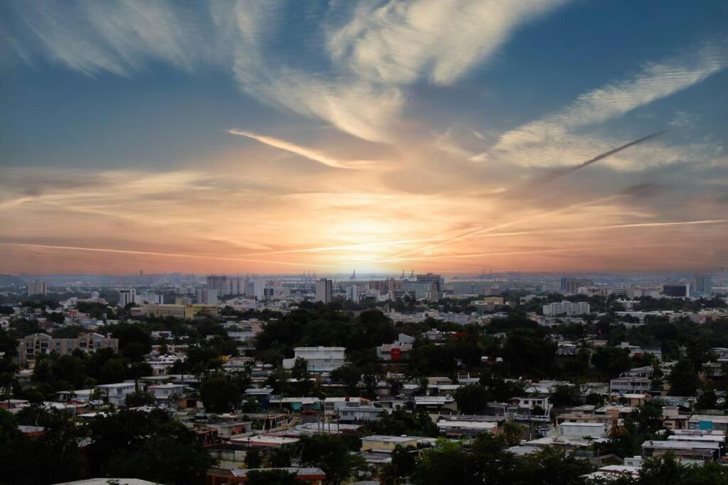 a city skyline with the sun setting in the sky at Penthouse Views in San Juan