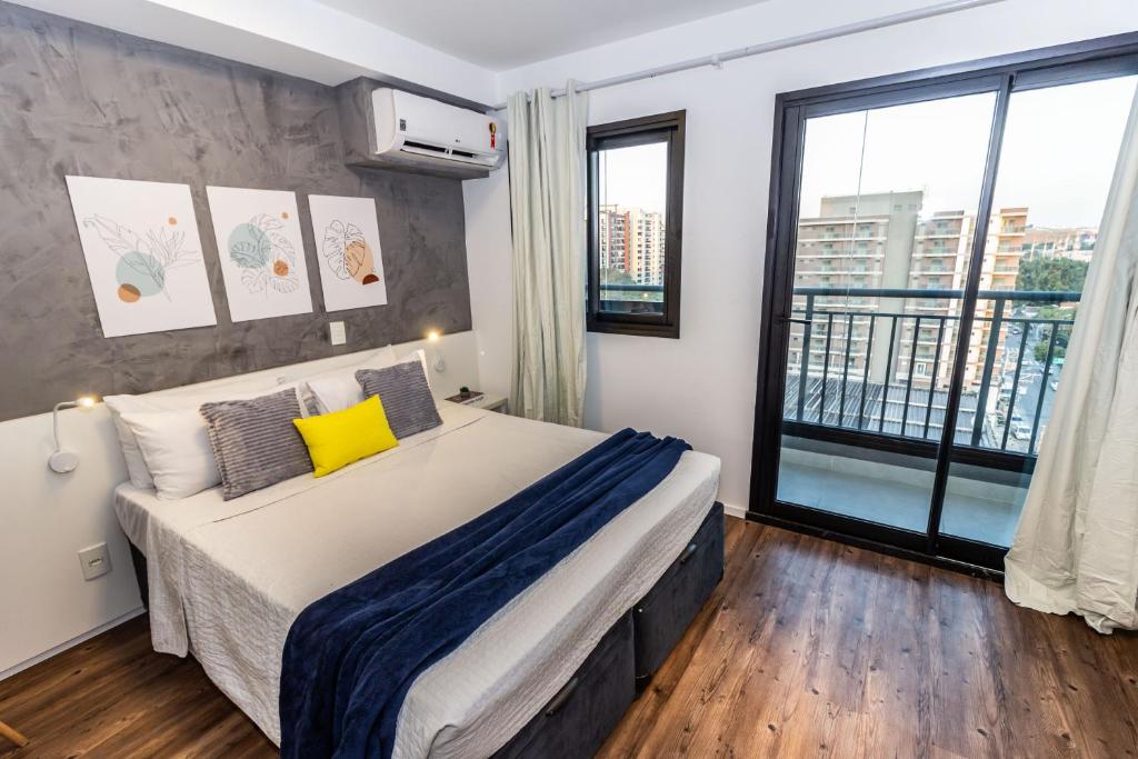 een slaapkamer met een groot bed en een groot raam bij 360 Moema in Sao Paulo