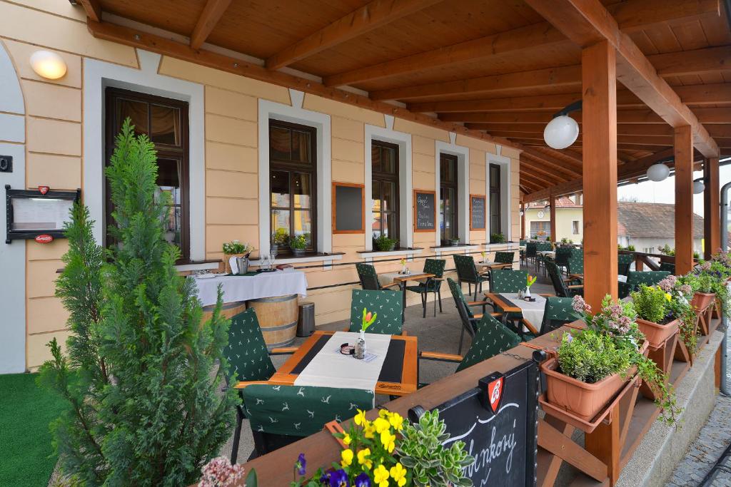 un patio esterno con tavoli, sedie e fiori di Hotel Podhrad a Hluboká nad Vltavou