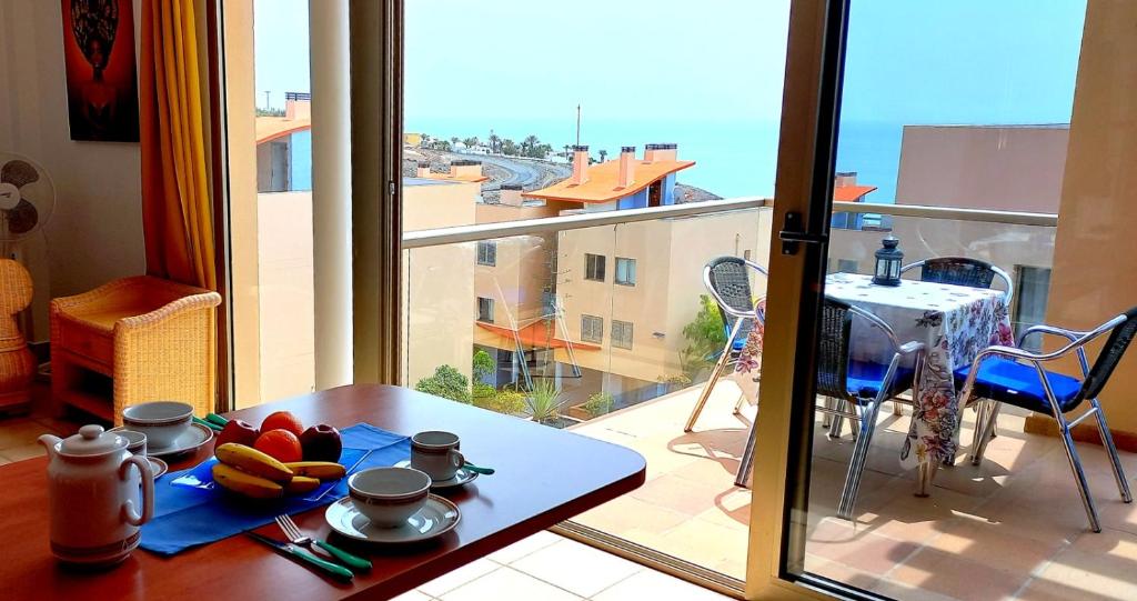 Habitación con mesa y vistas a un balcón. en Apartamento del Mar, en Playa de Jandía