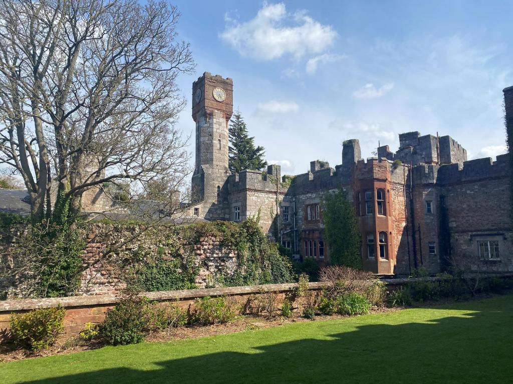 a castle with a clock tower on top of it at Ruthin Castle Hotel and Spa in Ruthin