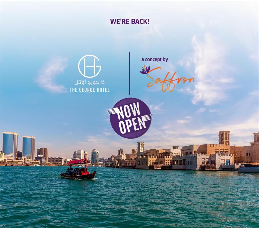 a boat on the water with a city in the background at The George Hotel by Saffron, Dubai Creek in Dubai