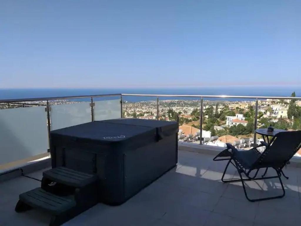 una mesa y sillas en un balcón con vistas en Panoramic Holidays - Premium 9, en Peyia