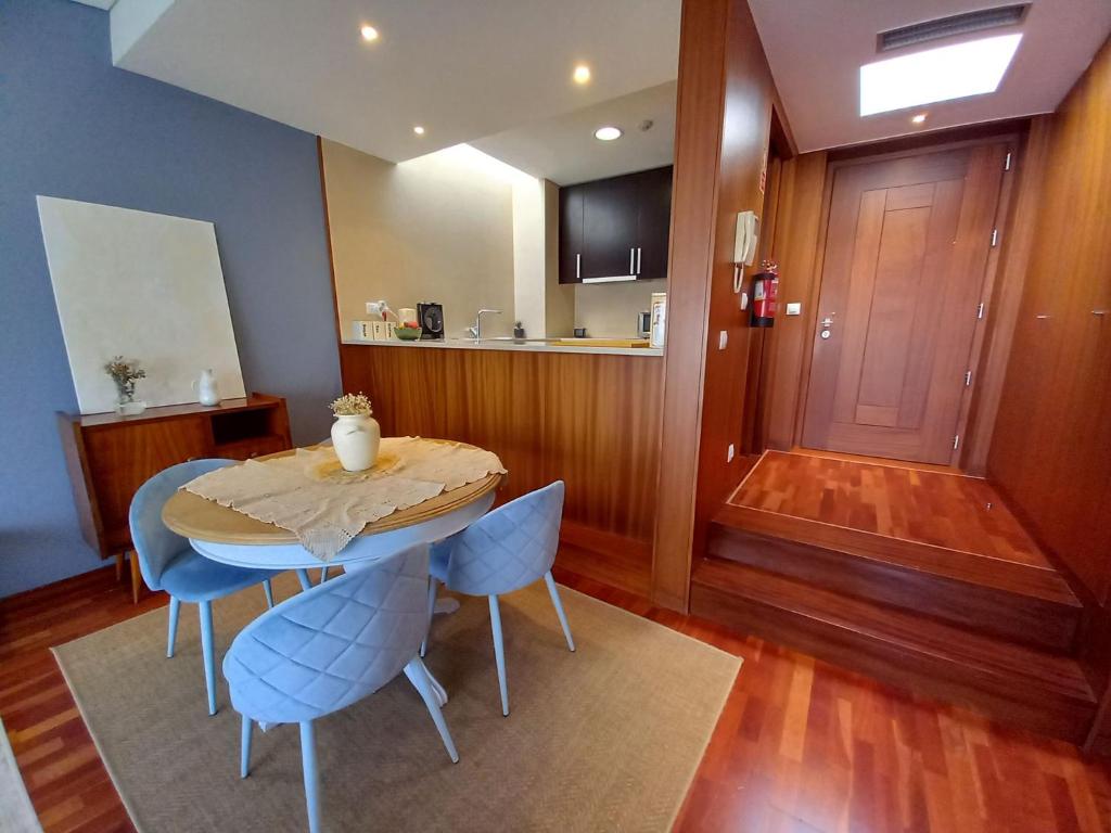 a dining room with a table and blue chairs at Cabedelo Beach Apartment in Viana do Castelo