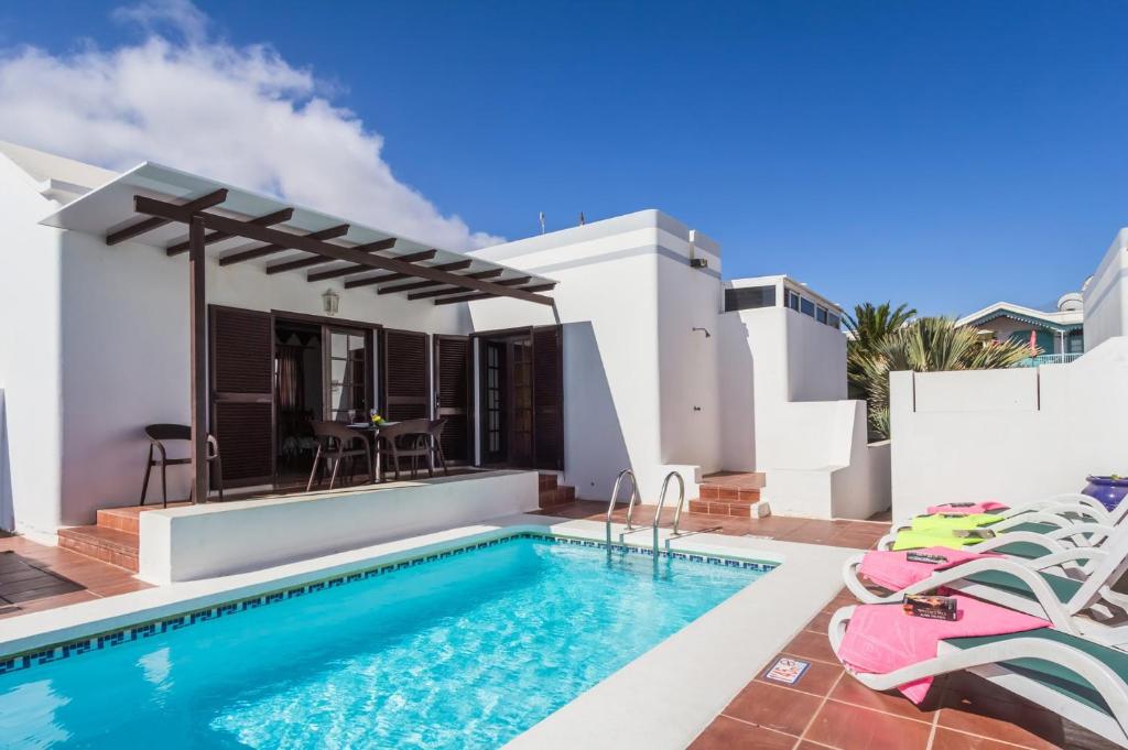 uma villa com uma piscina e uma casa em Villa Denise by Villa Plus em Tías