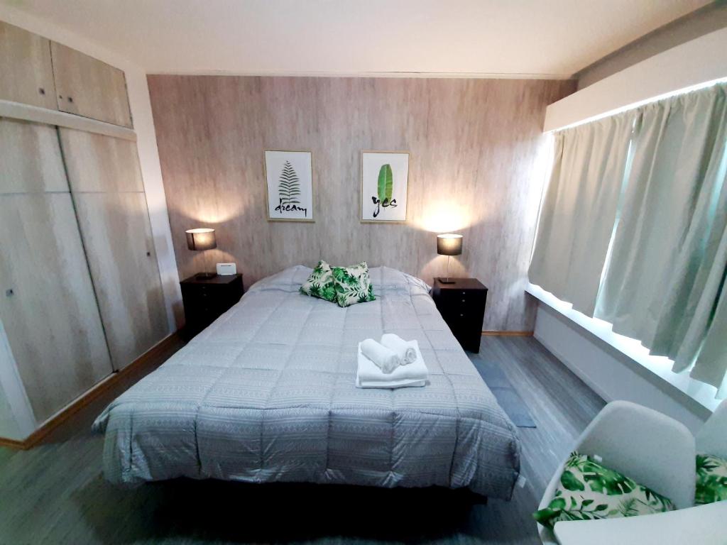 Un dormitorio con una cama con dos toallas encima. en Center 208 - DAT (Habilitación 170/2018), en San Carlos de Bariloche