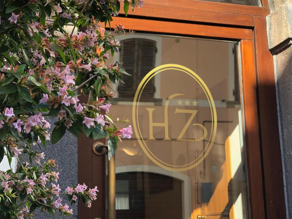 a glass door with a sign on it with pink flowers at Hotel Zodiaco in Bolsena