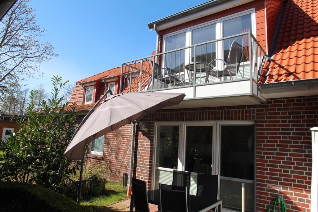 een balkon met een paraplu voor een huis bij Friesenkoje in Norddeich