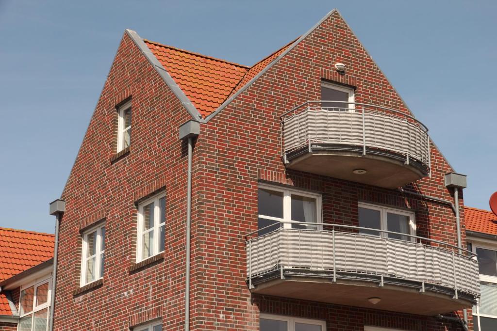 a red brick building with two balconies on it at Friesennest in Norddeich