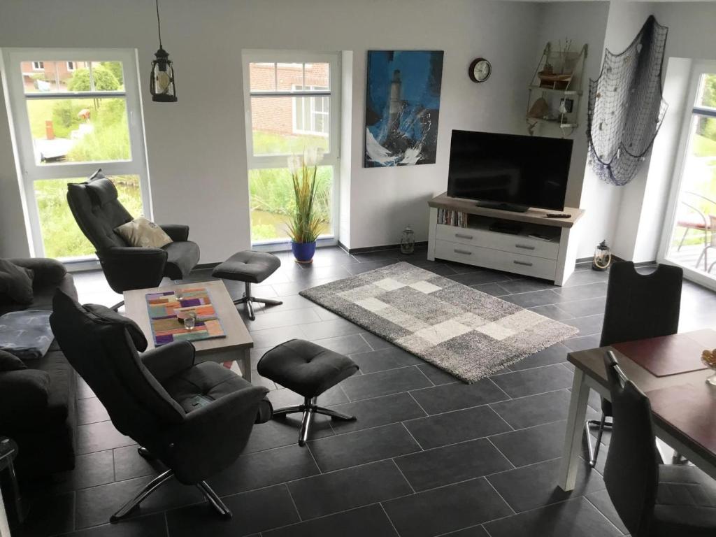 a living room with chairs and a flat screen tv at GrachtenGlück in Greetsiel