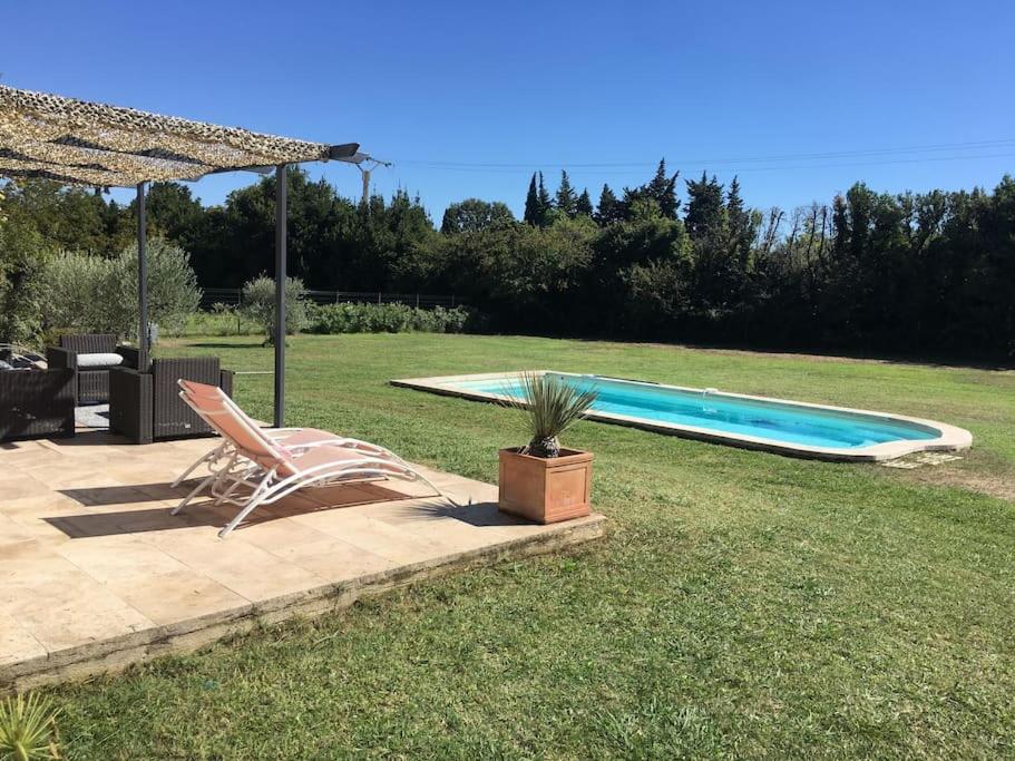 une terrasse avec une chaise et une piscine dans l'établissement Villa Alpilles, à Mouriès