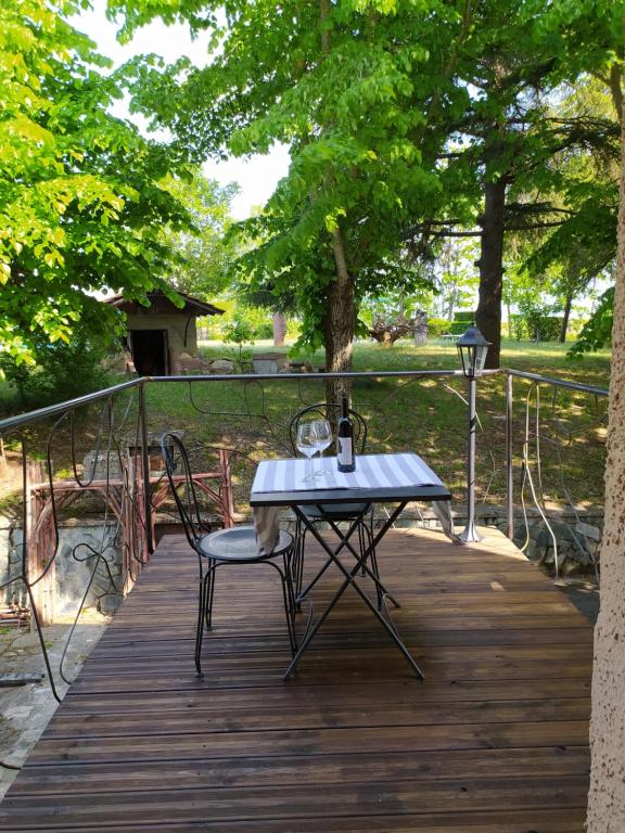 una mesa y 2 sillas en una terraza de madera en Agriturismo Podere Luciano, en Acqui Terme
