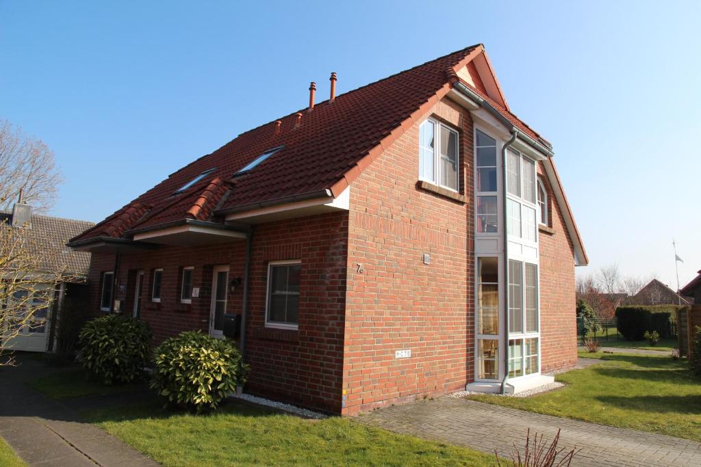 a red brick house with a brown roof at Robbeninsel in Norden