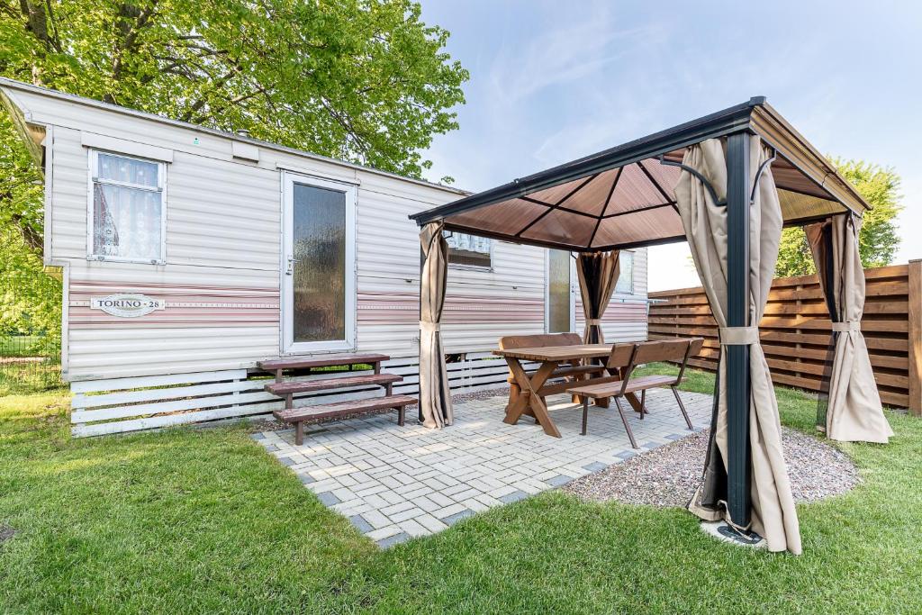 a patio with a table and an umbrella and a bench at Atokaita in Palanga