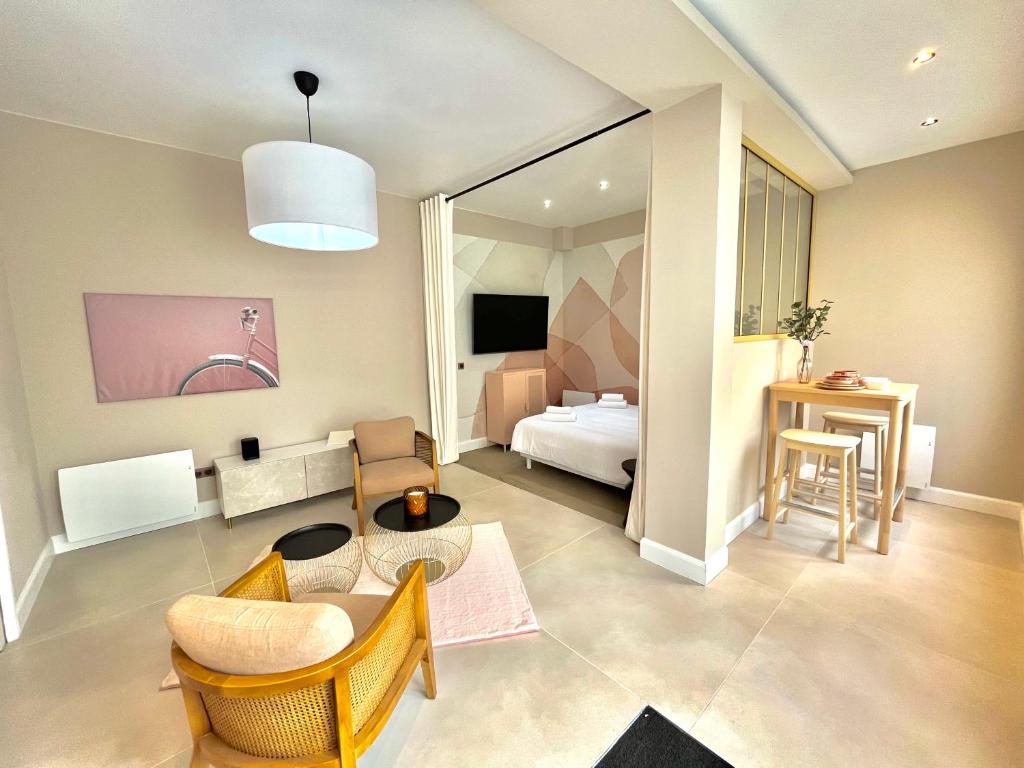 uma sala de estar com uma cama, uma mesa e cadeiras em Suite Monceau - Reims em Reims