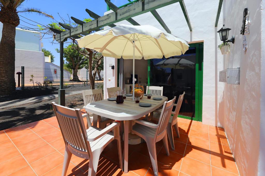 un tavolo e sedie con ombrellone su un patio di Paradise L1, central Puerto del Carmen a Puerto del Carmen