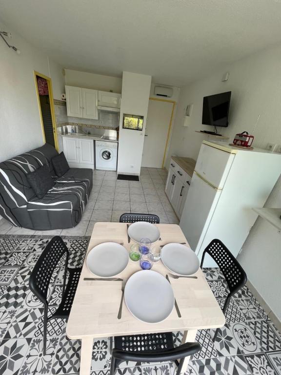 cocina y sala de estar con mesa y sillas. en Appartement familial à 50m de la plage - Narbonne Plage - 4LBM492, en Mosset