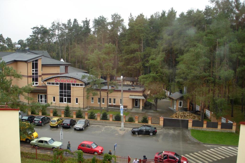 a parking lot with cars parked in front of a building at Hotel-Restaurant Complex Vensky in Brovary