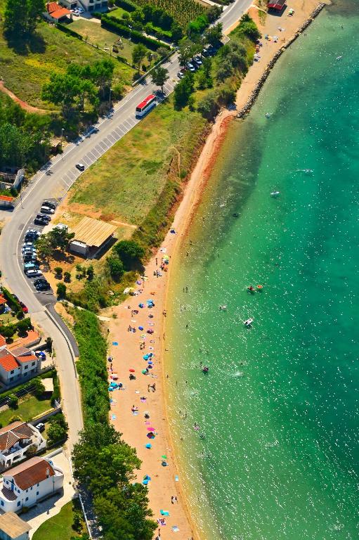 an aerial view of a beach with people and the ocean at La Selina Nin in Nin