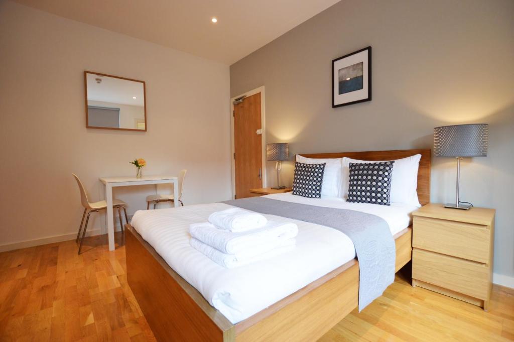 a bedroom with a large white bed with a desk at Russell Square Serviced Apartments by Concept Apartments in London