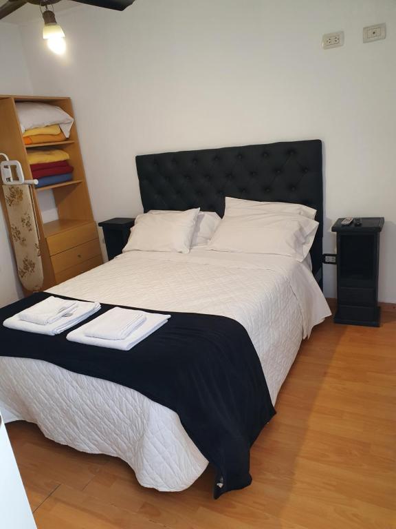 a bedroom with a large bed with a black headboard at fucsia in Rosario