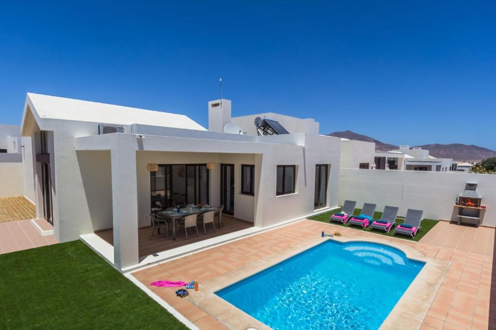 een villa met een zwembad voor een huis bij Villa Estrella by Villa Plus in Playa Blanca