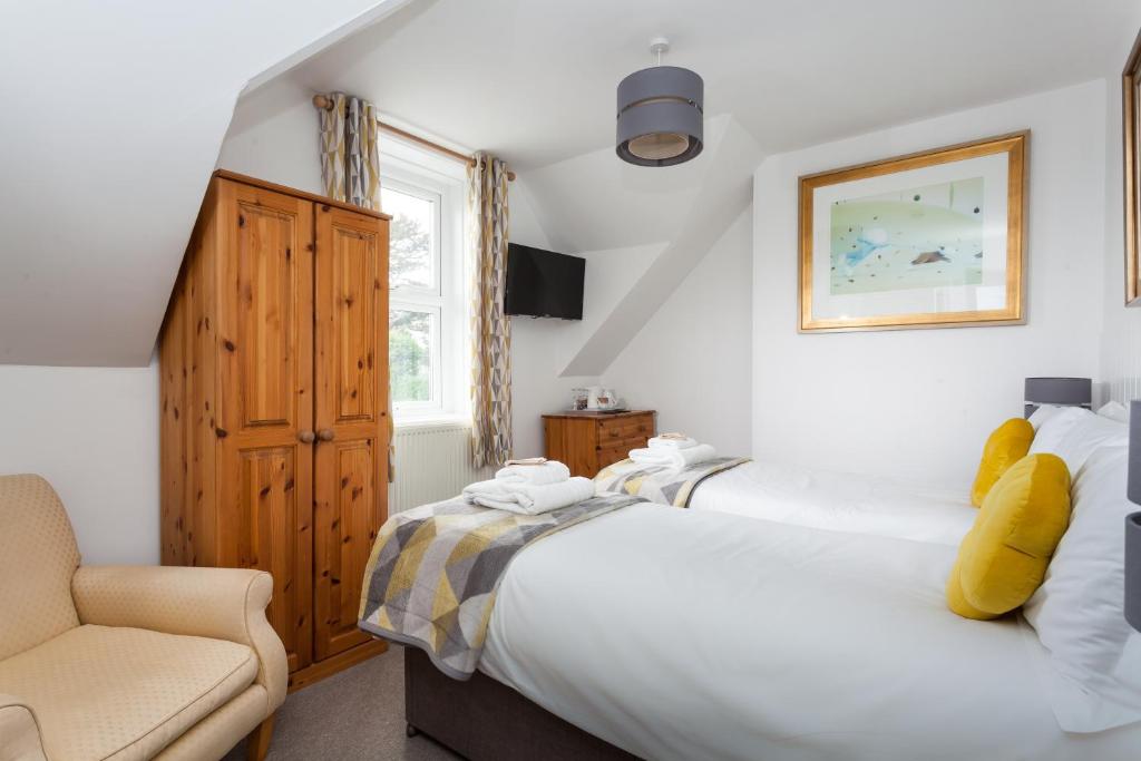 un dormitorio con una cama y una silla en The Olive Branch, en St Ives