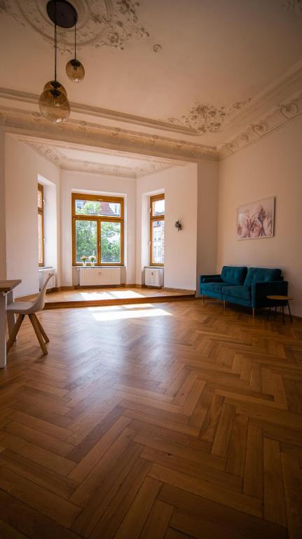 an empty living room with a blue couch and wooden floors at tRAUMhaus in Erfurt
