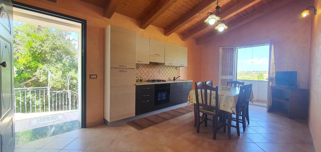 a kitchen with a table and chairs and a window at Cristian Apartaments in Capo Vaticano