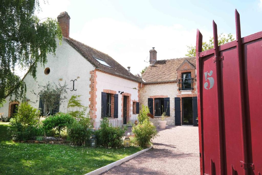 a house with a red gate in a yard at L'Orme Blanchet Spa & Piscine, petit-déjeuner inclus in Chambon-la-Forêt