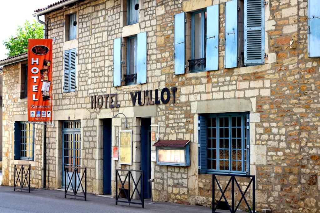 a brick building with a sign on the side of it at Logis Hôtel Restaurant Vuillot in Cuiseaux