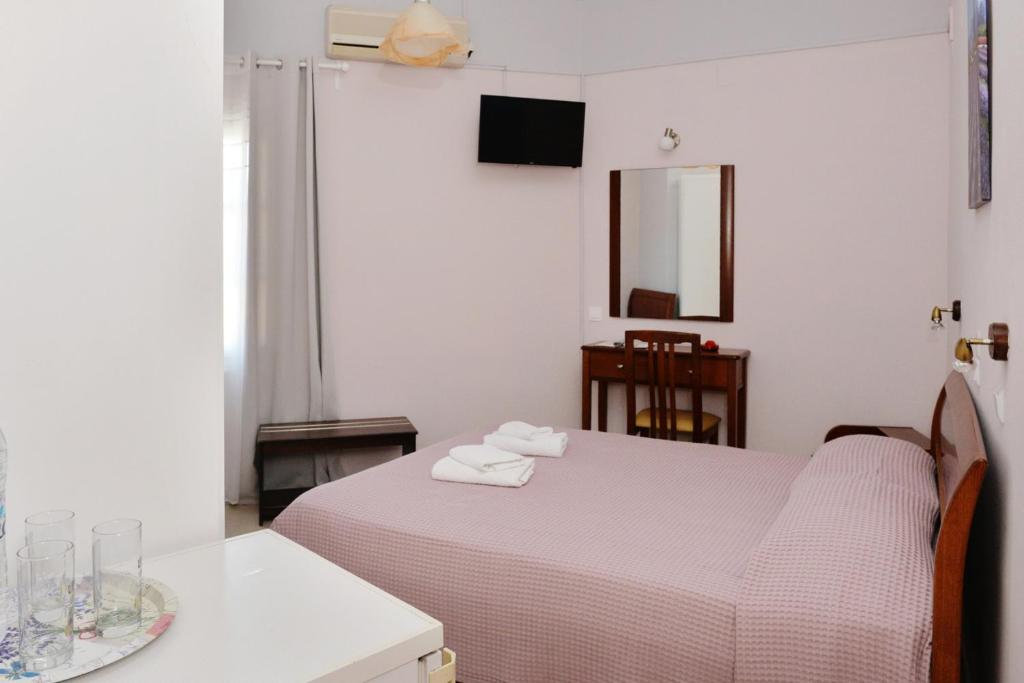 ein Schlafzimmer mit einem Bett mit zwei Handtüchern darauf in der Unterkunft Hotel Villa Plaza in Spetses