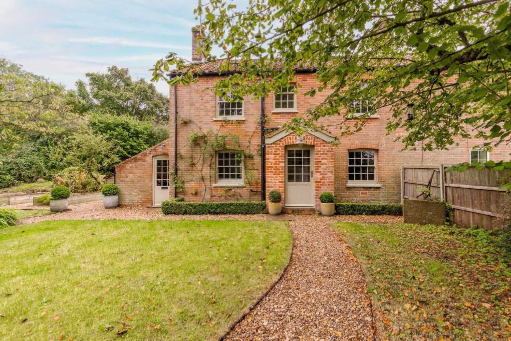 a brick house with a yard in front of it at Haclins Cottage - Norfolk Holiday Properties in Fakenham