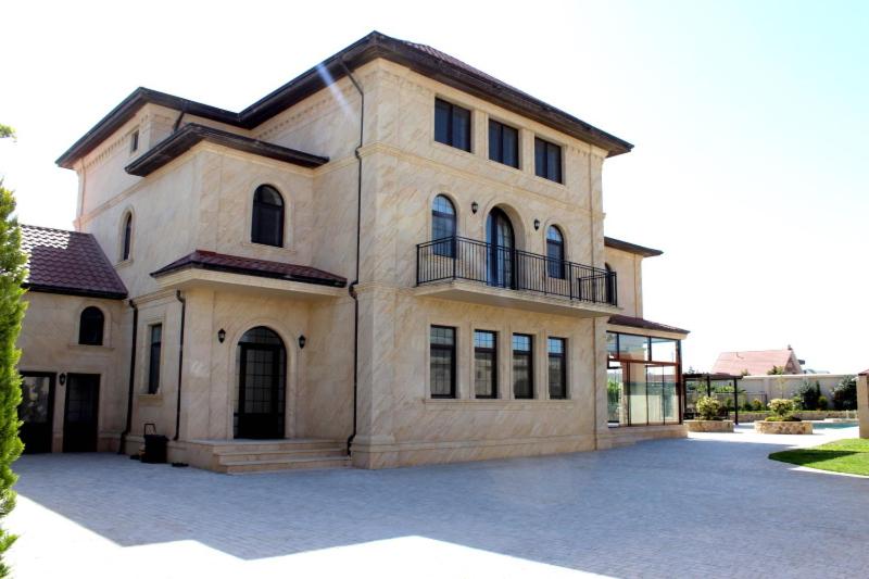Cette grande maison en pierre possède de nombreuses fenêtres. dans l'établissement Villa Gilavar, à Baku