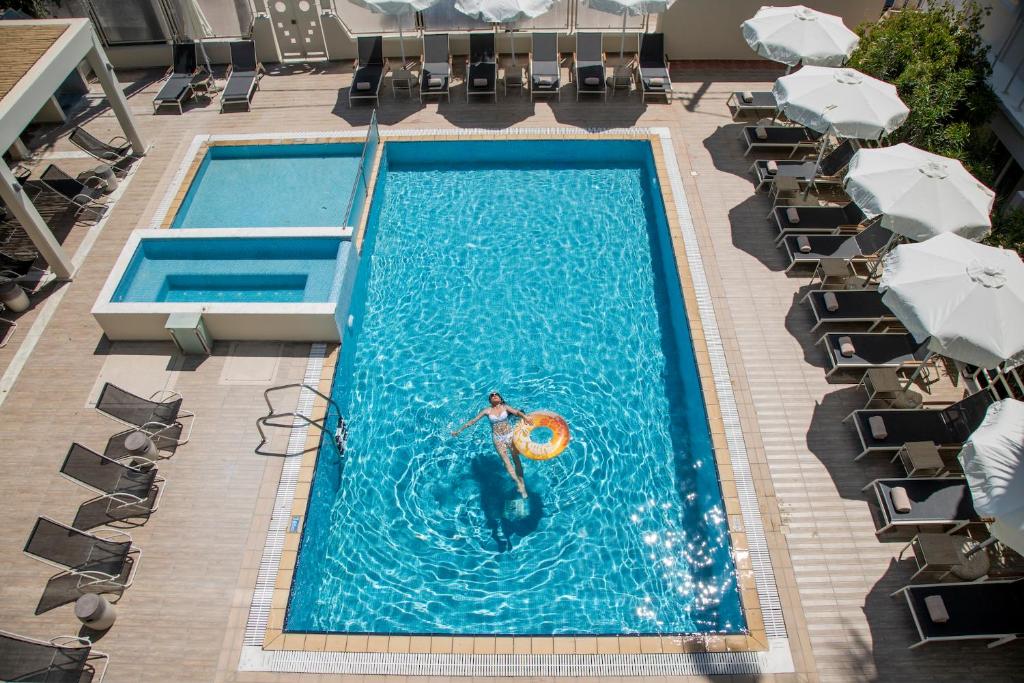 a person in a pool with a lifebuoy in the water at KoSea Boutique Hotel in Kos