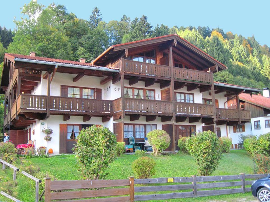 uma grande casa de madeira com uma cerca em frente em Ferienwohnung Bergblickl em Sachrang