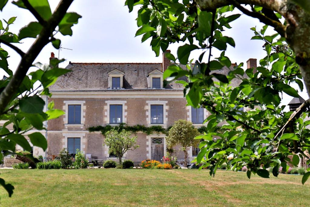 a large brick house with a grass yard at La Demeure de l'Aubance in Saint-Mélaine-sur-Aubance