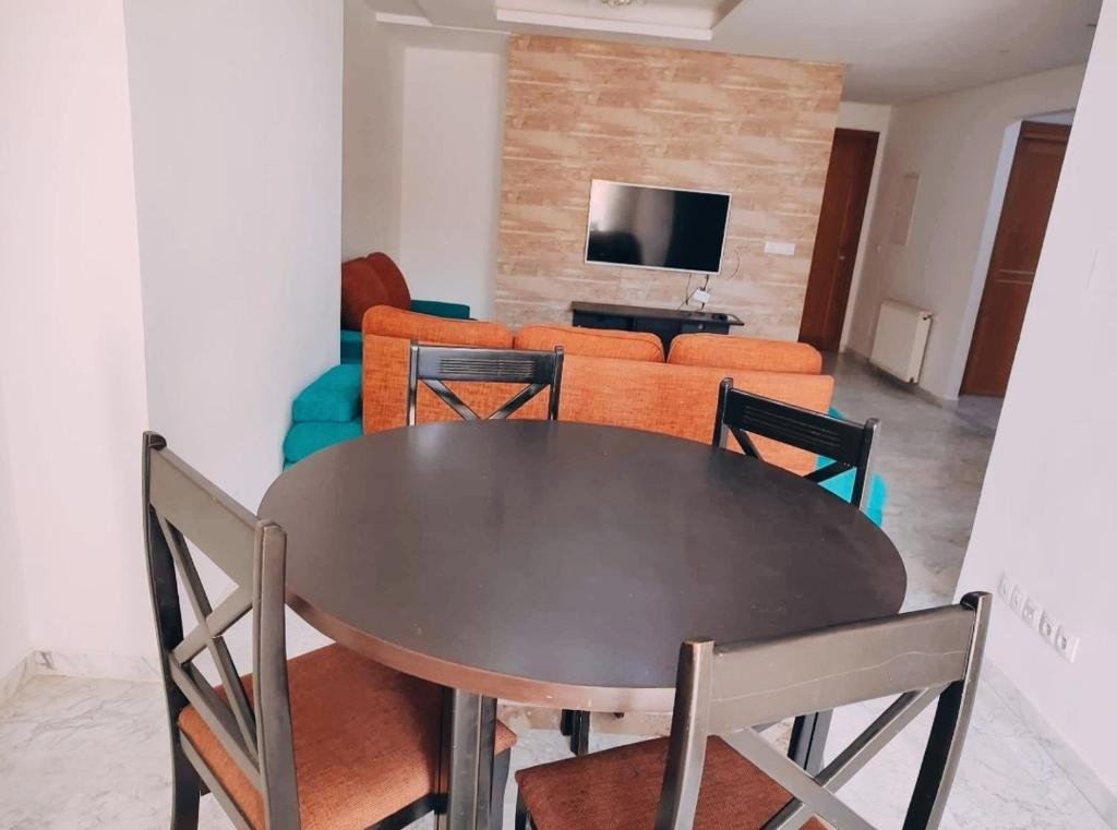 Vacances de charme في سوسة: طاولة وكراسي في غرفة معيشة مع أريكة