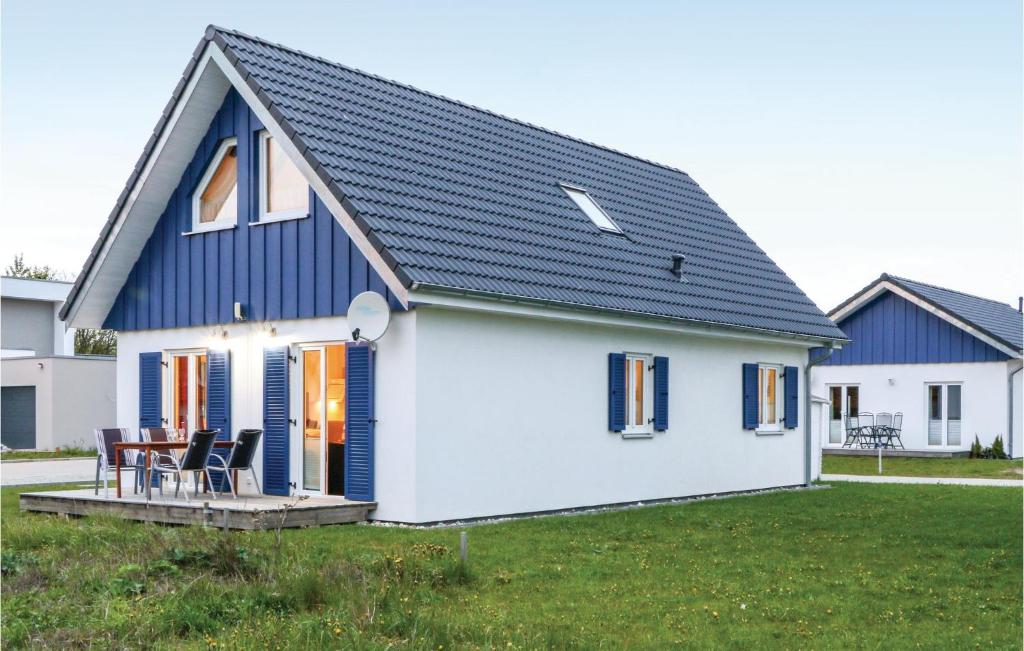 ein kleines weißes Haus mit blauem Dach in der Unterkunft Ferienhaus 2 Altefhr in Altefähr