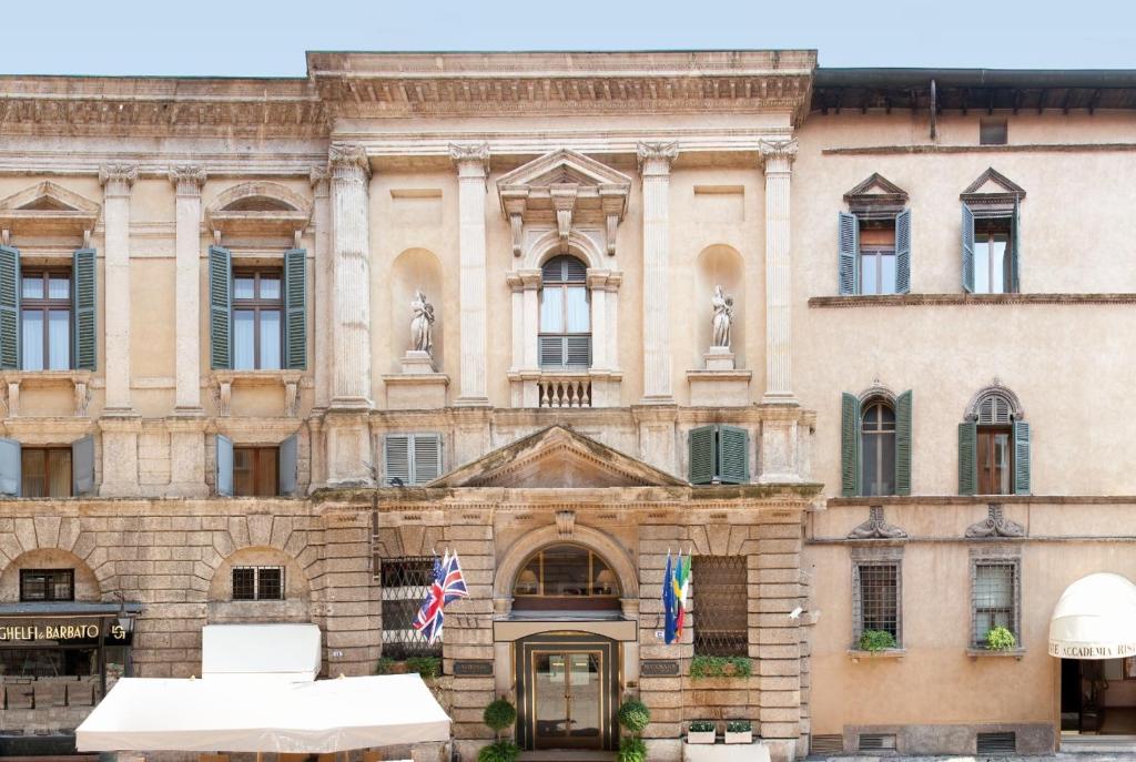 um edifício antigo com bandeiras à frente em Hotel Accademia em Verona