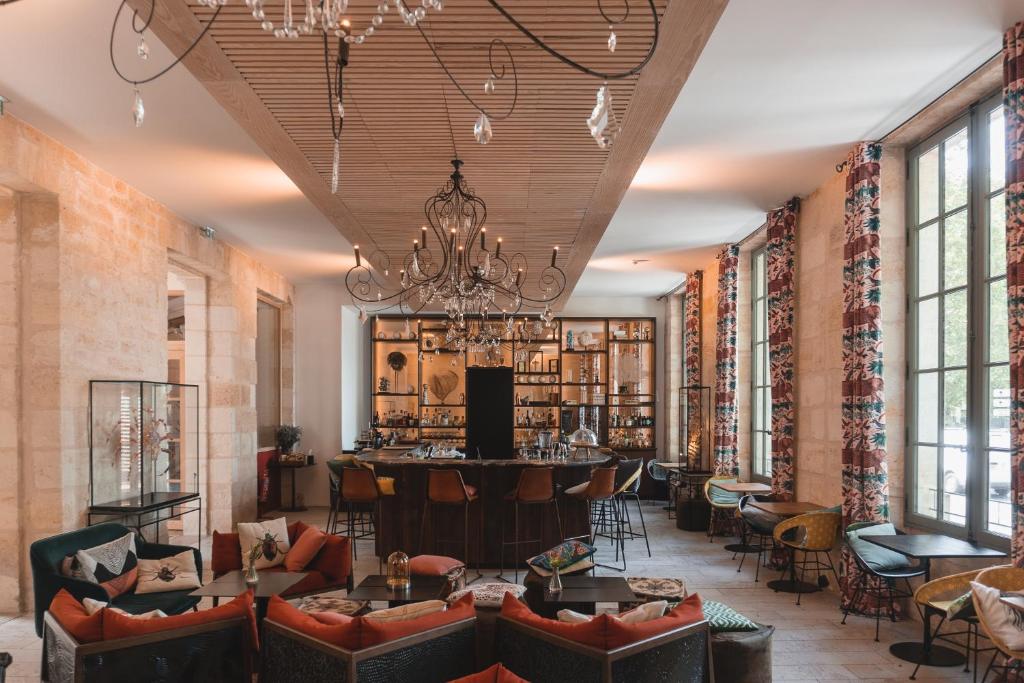 a lobby with couches and a bar in the middle at Hotel La Zoologie & Spa Bordeaux in Bordeaux