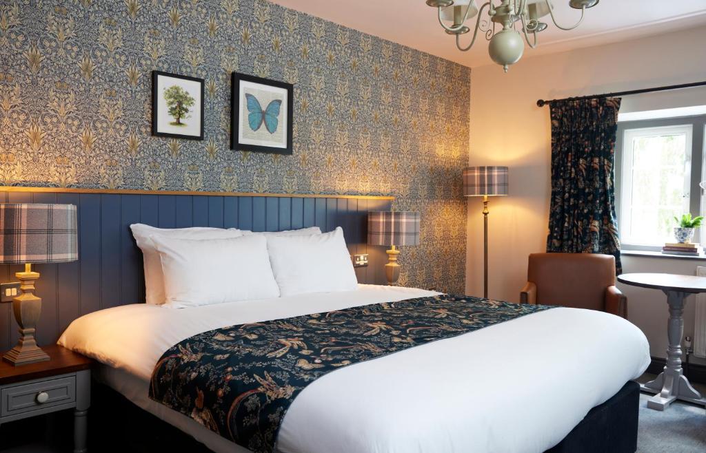 ウィットニーにあるRose Revived by Chef & Brewer Collectionの大きなベッドと窓が備わるホテルルームです。