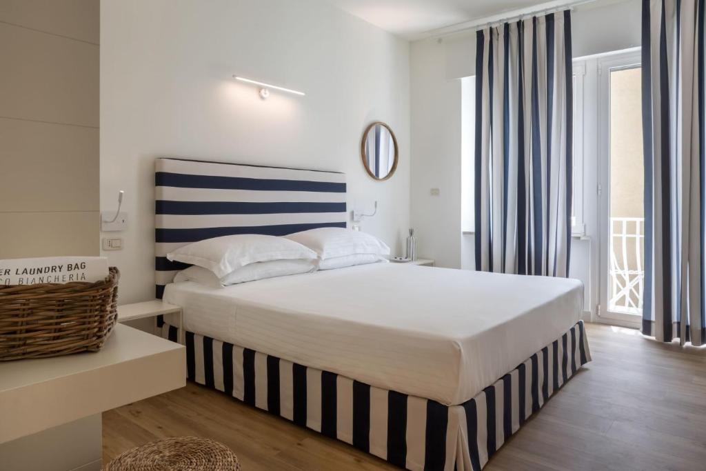 een slaapkamer met een bed met een blauw en wit gestreept hoofdeinde bij Murè Hotel Numana in Numana