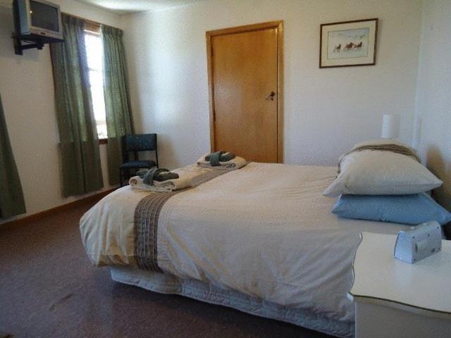 a bedroom with a bed with two pillows on it at The Pier Lodge Bed And Breakfast in Christchurch