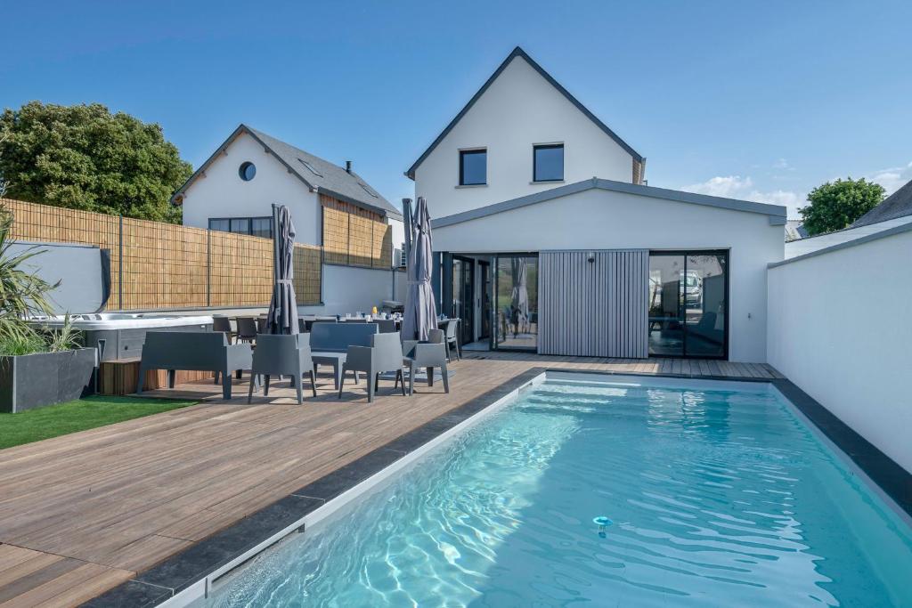 a backyard with a swimming pool and a house at Villa moderne avec piscine pour 15 personnes ! in Saint-Gildas-de-Rhuys