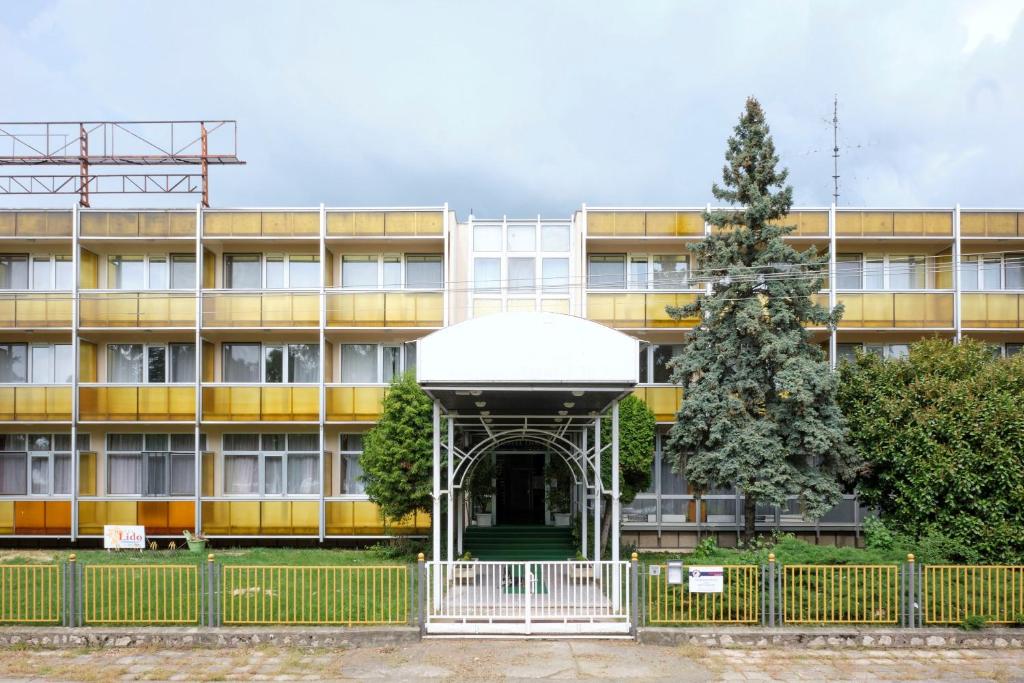 una vista exterior de un edificio con un árbol en Retro Lido - Vonyarcvashegy en Vonyarcvashegy